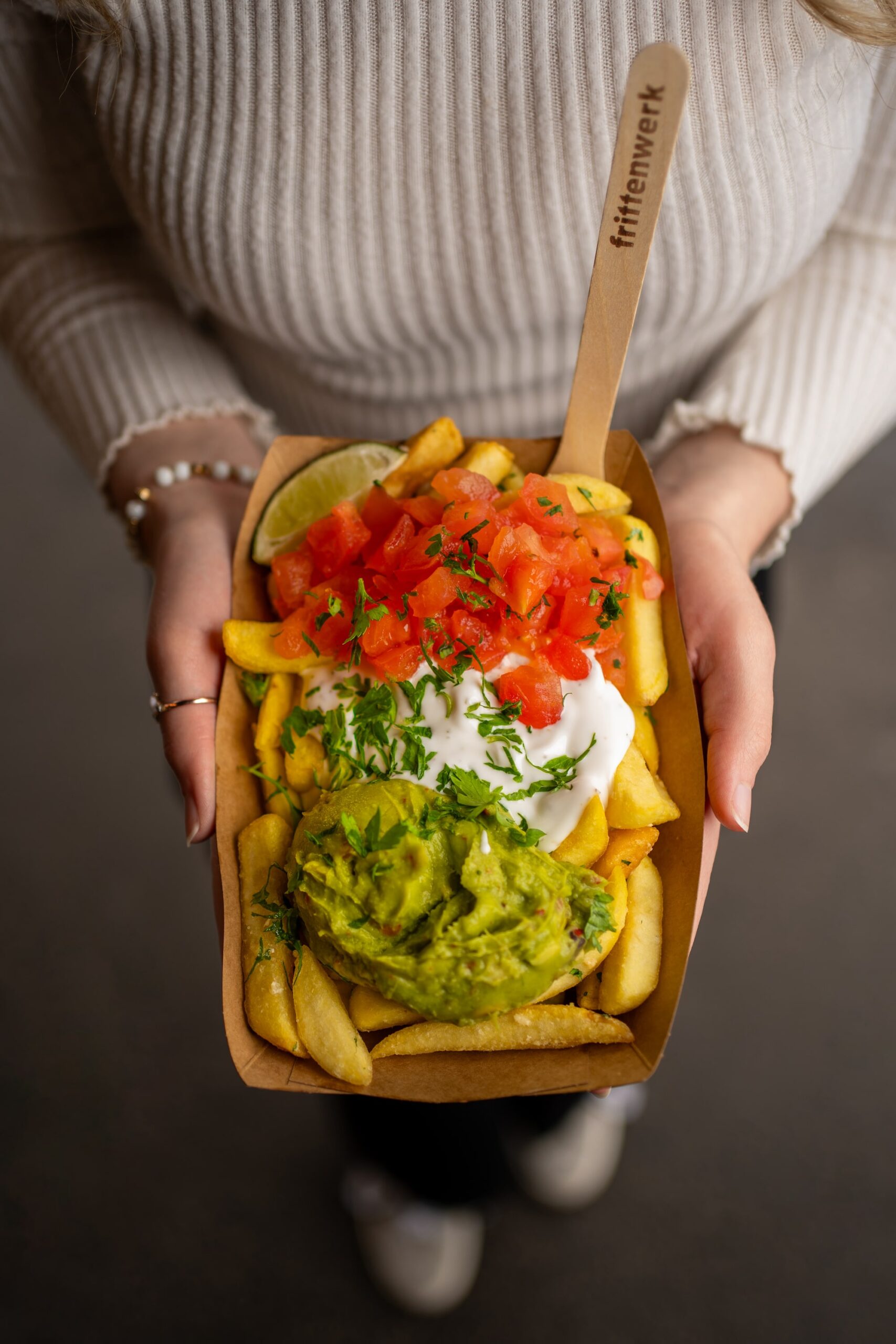 Frittenwerk loaded fries featuring creamy guac, sour cream, and lime.